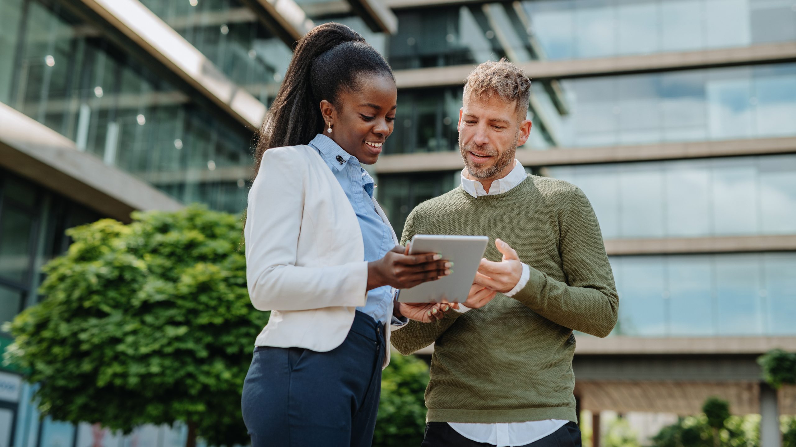 Two colleagues consulting their ipad looking at space reservation options within their workplace