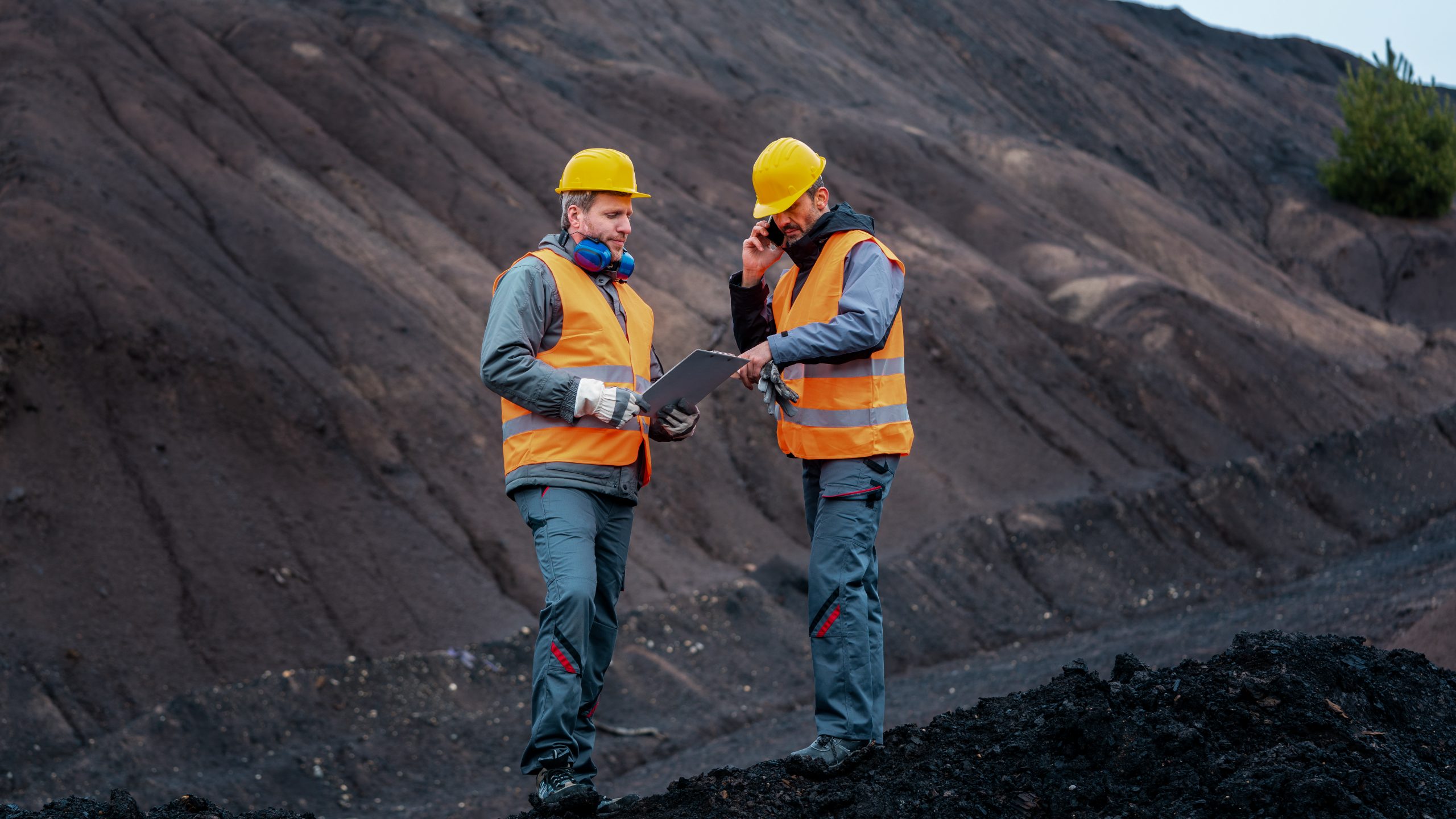 Frontline workers standing in open-cast mining operation pit - showing communication challenges for deskless workers