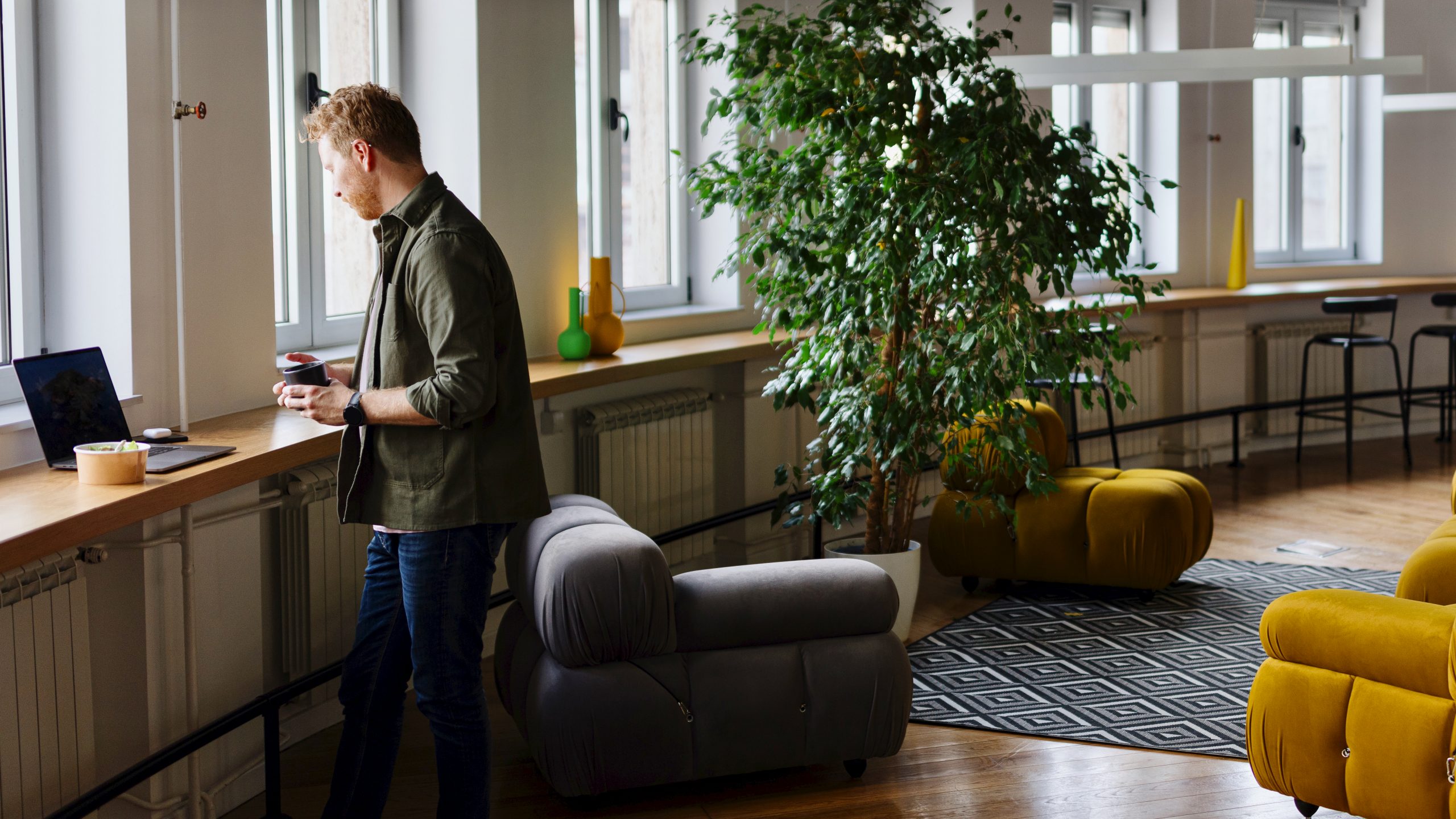 Employee reviewing occupancy data on laptop, highlighting the gap between booked and actual office space usage